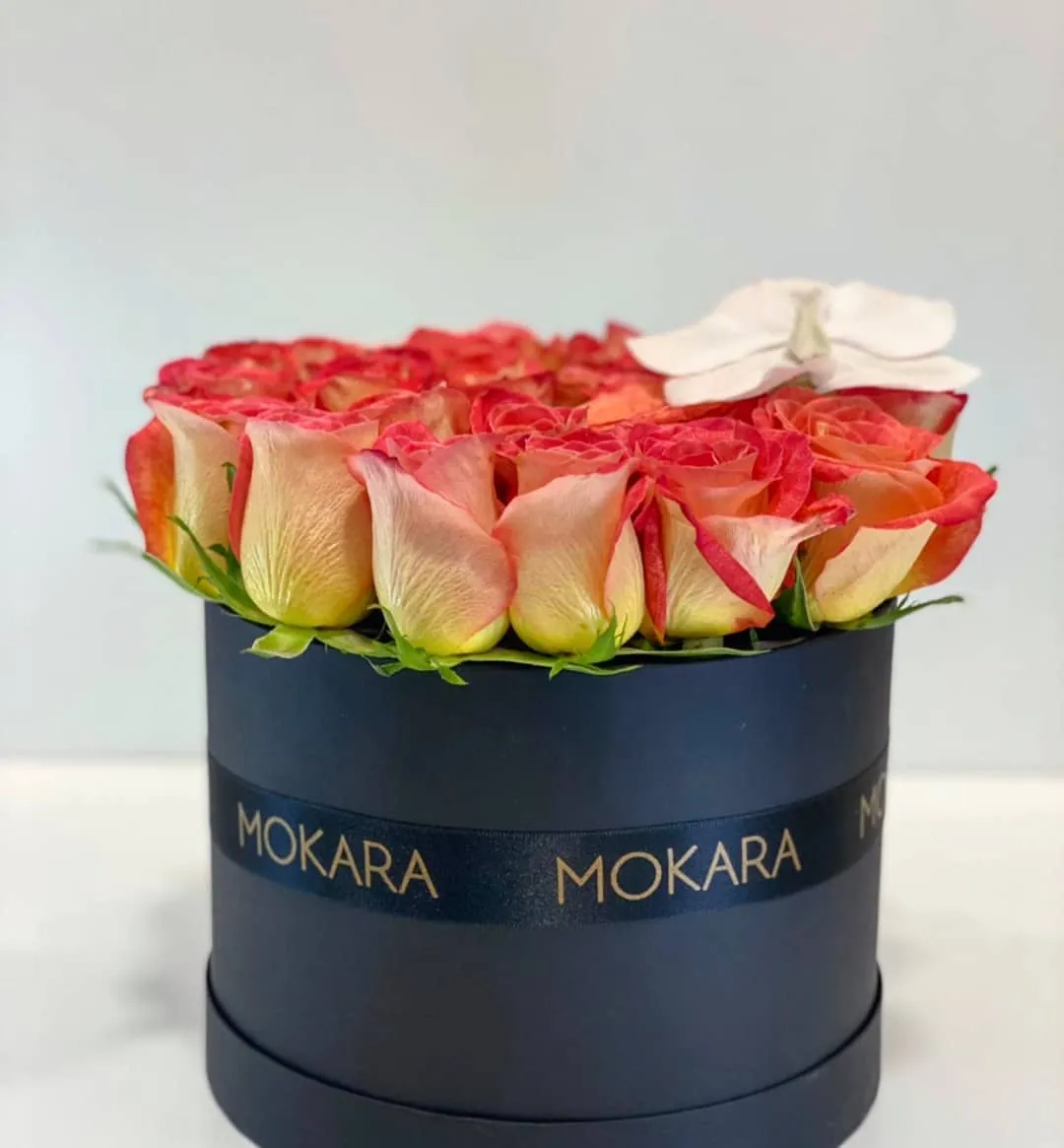 Rosas naranjas con orquídea blanca en caja negra de Mokara