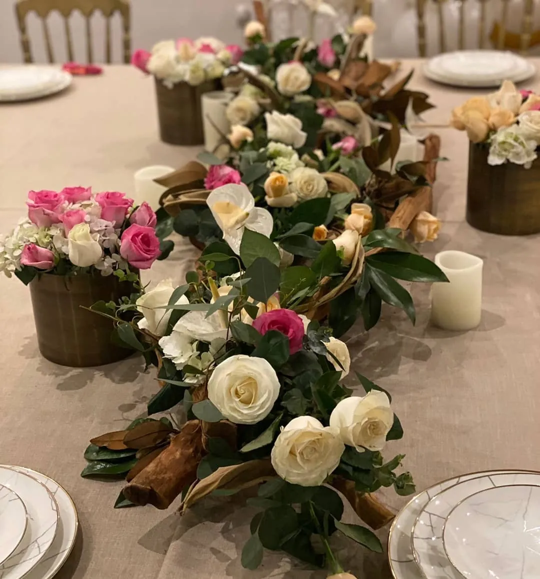 Camino de mesa con magnolia seca y rosas en tonos tierra, con velas bajas
