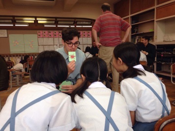 A coach practicing English pronunciation with a small group of junior high students