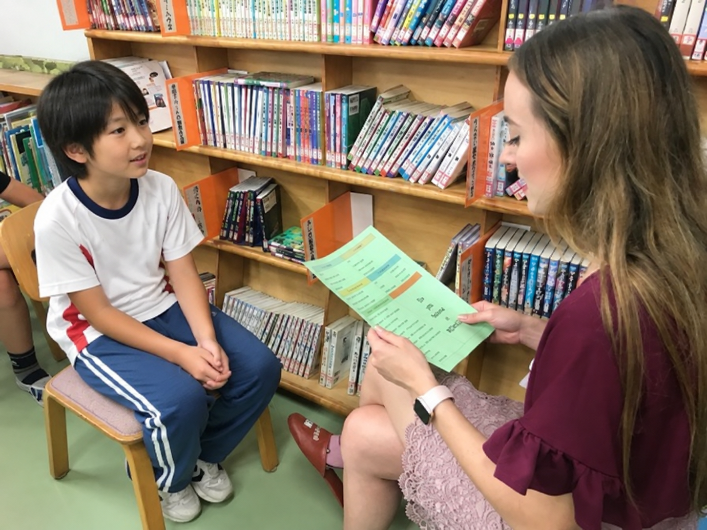 An English coach practicing one-to-one conversation with an elementary school student