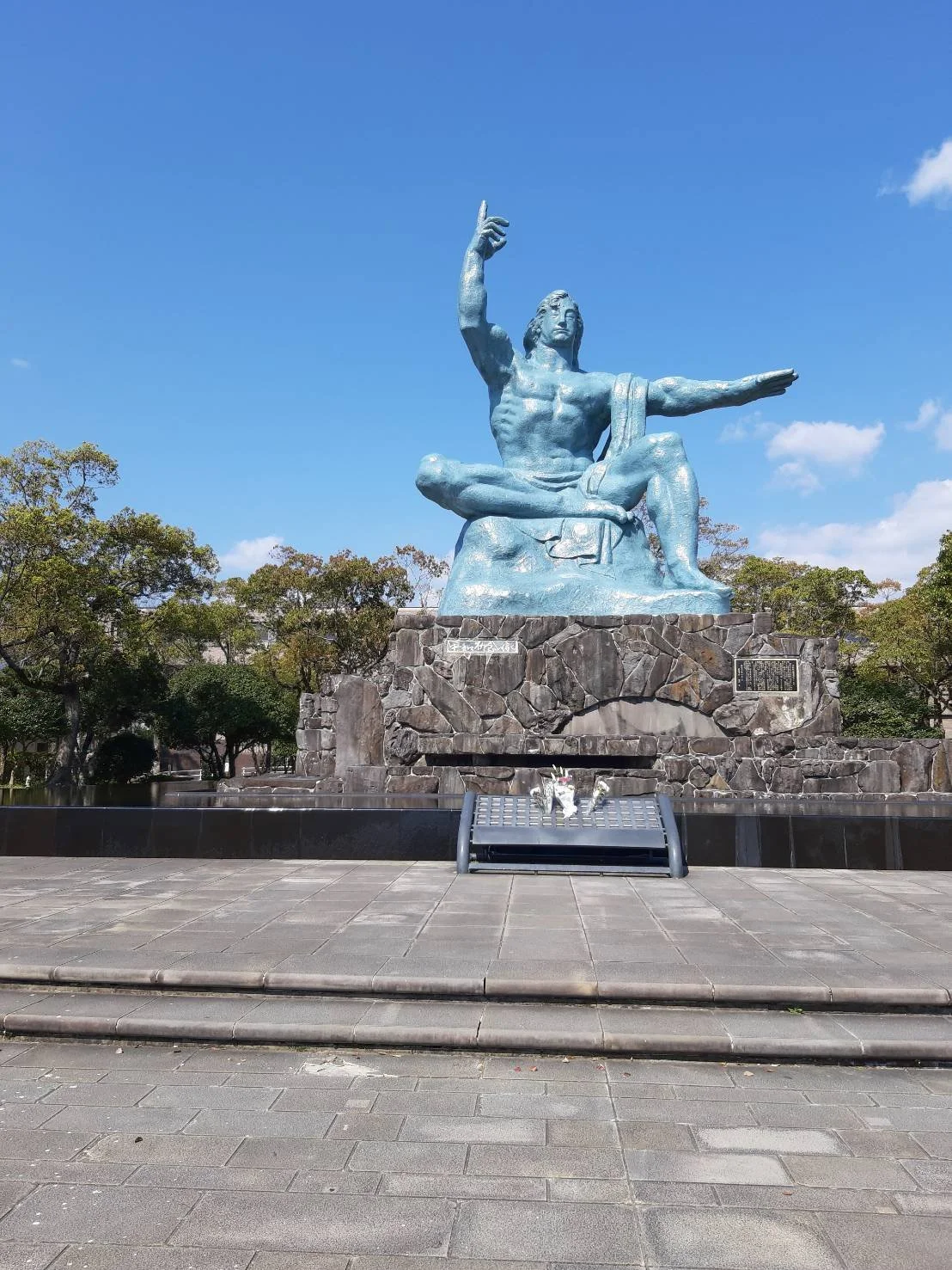 The Peace Statue in Nagasaki Peace Park, Japan, under a blue sky