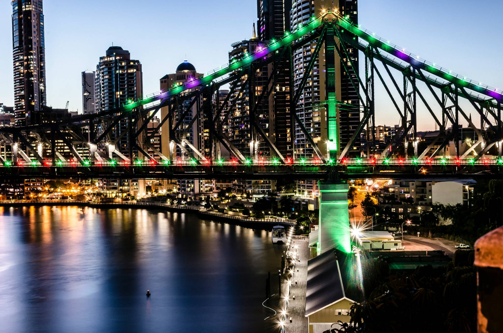Story Bridge in Brisbane illuminated at night with colorful lights, reflecting off the Brisbane River, a stunning sight to enjoy on a working holiday Brisbane.