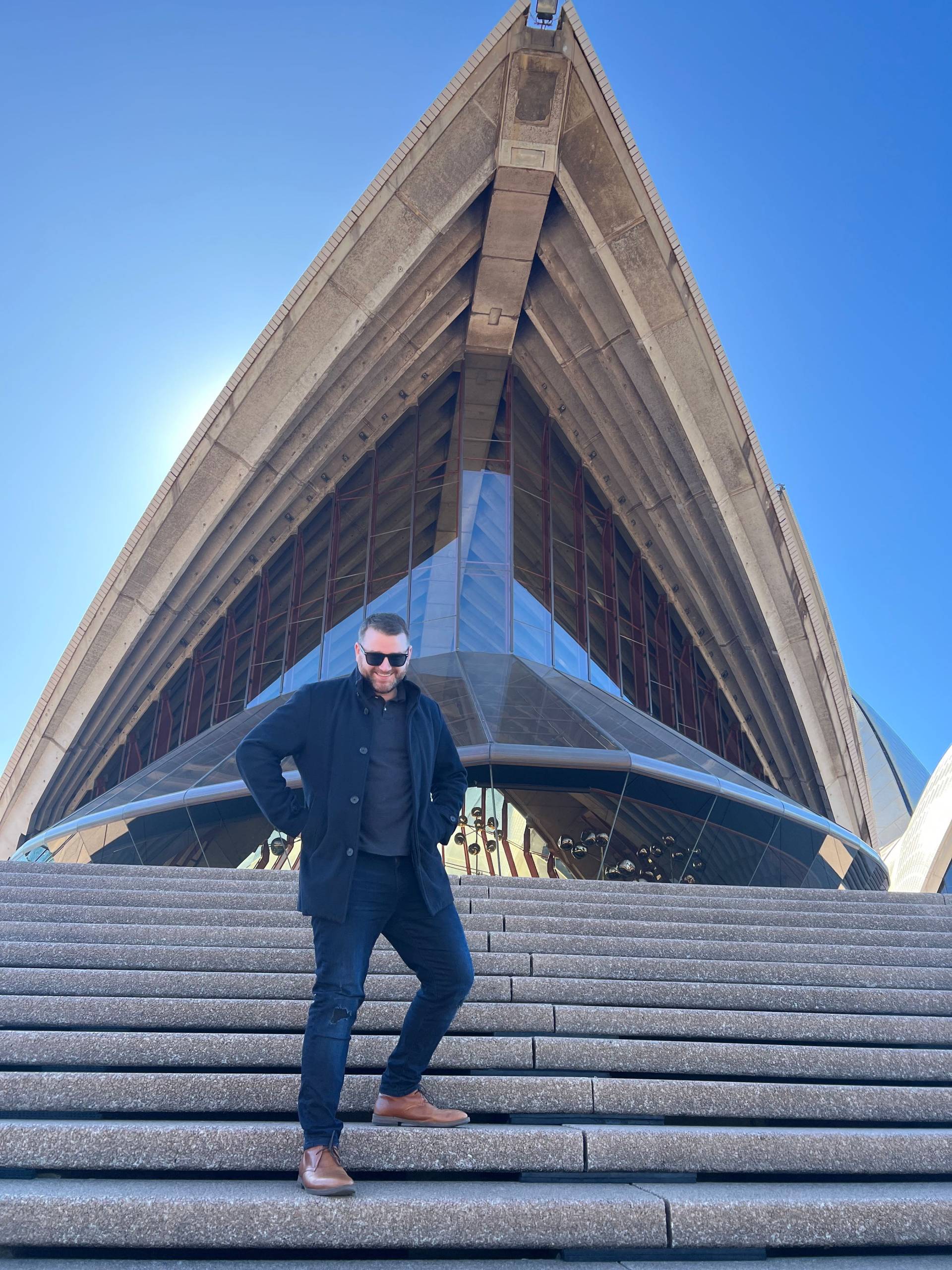 Darren Jonathon from Average joe down under outside the Sydney Opera House NSW on his working holiday visa