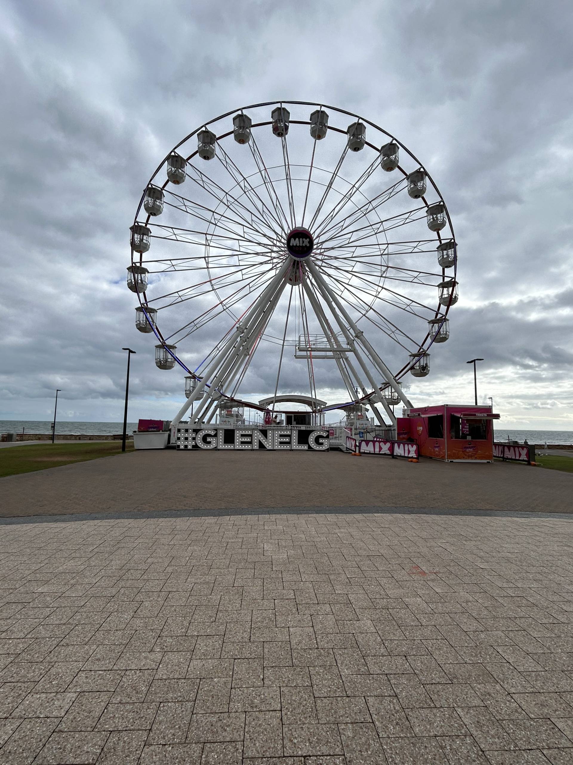Glenelg ferris wheel down by the beach on a cloudy day.