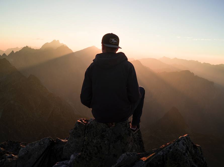 A person looking out over the water at sunrise