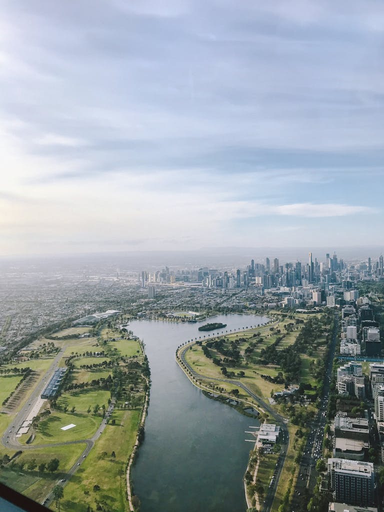Breathtaking aerial view of Melbourne skyline along the Yarra River with lush greenery.