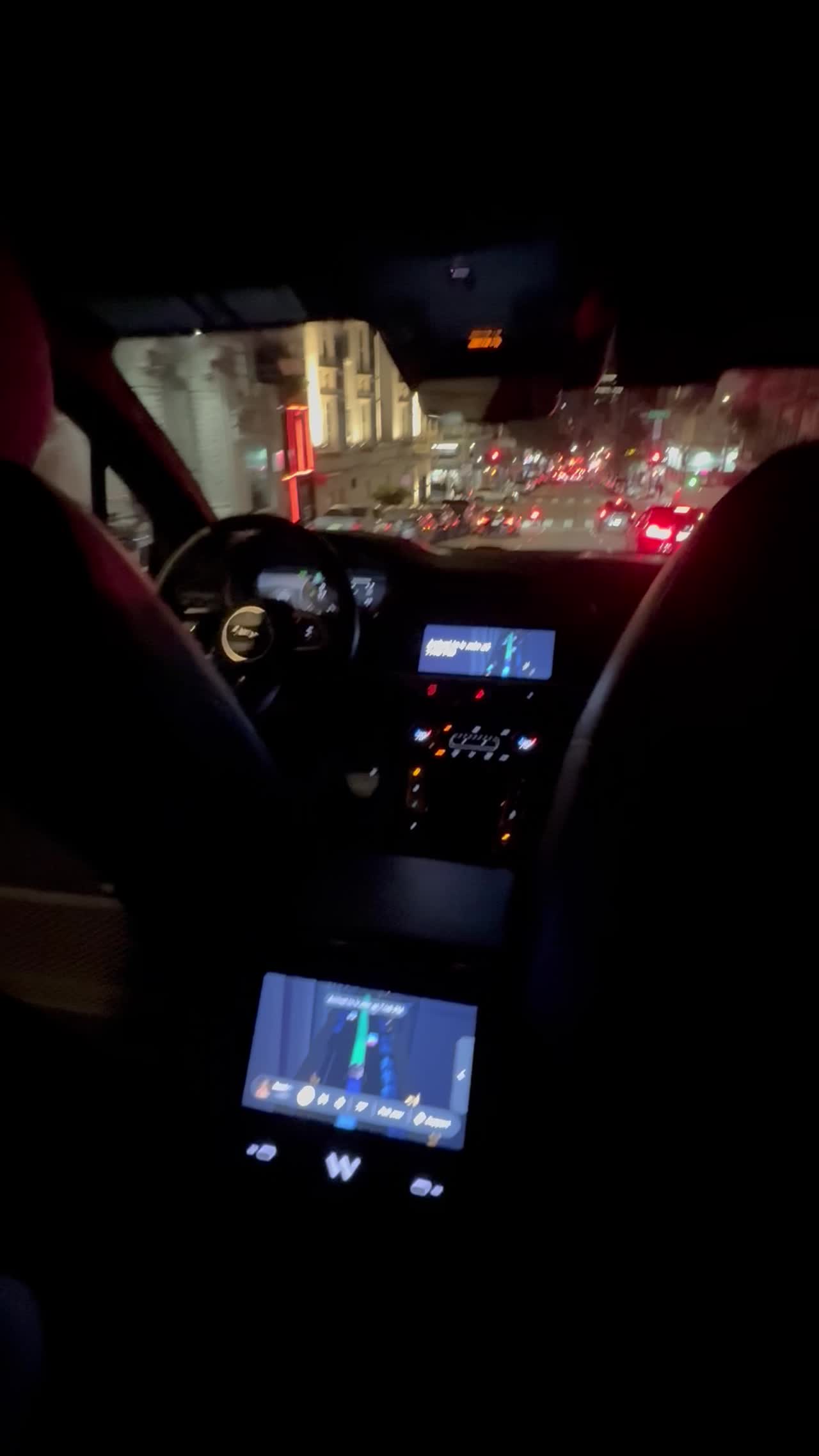 Inside the Waymo at night, with the screen showing the route through San Francisco