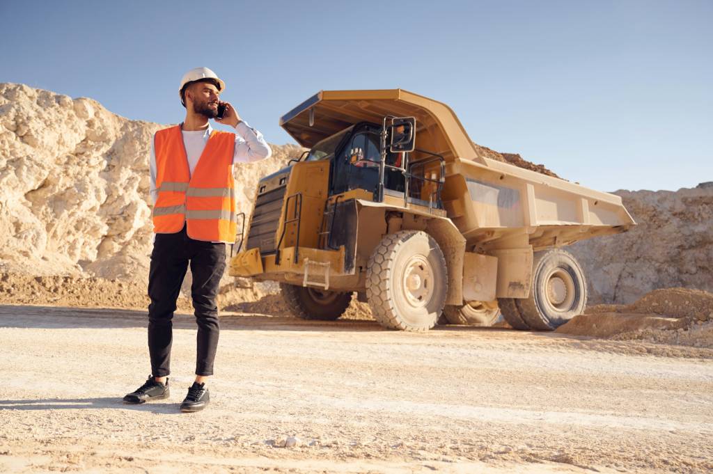 Man standing with Fifo mining trucks.