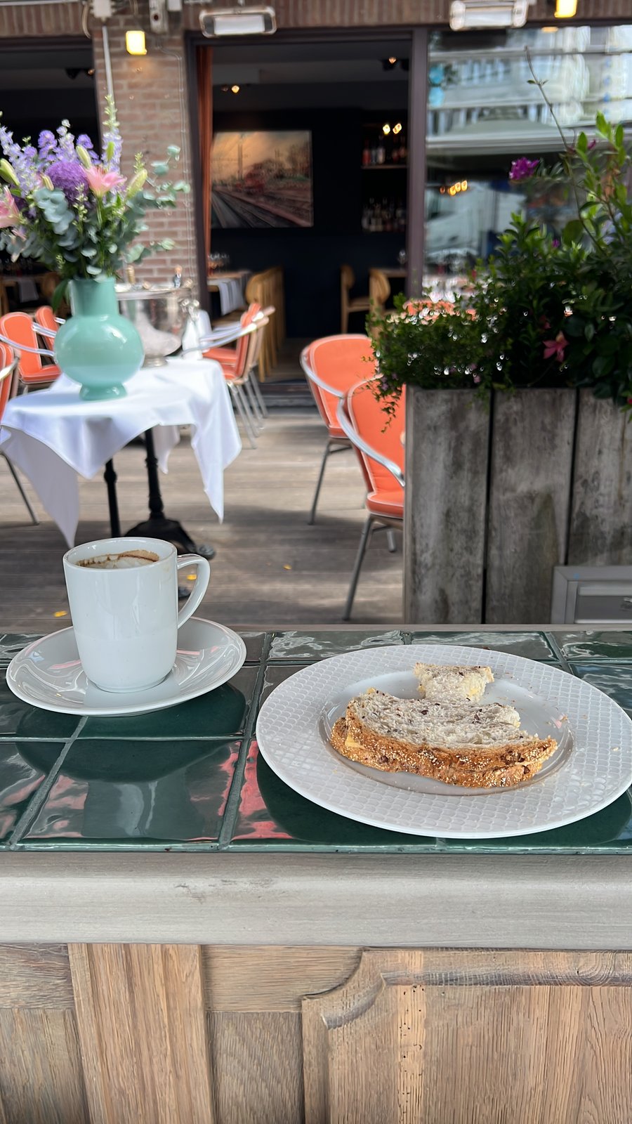 De zomerbar met lichtslingers en gasten aan het terras