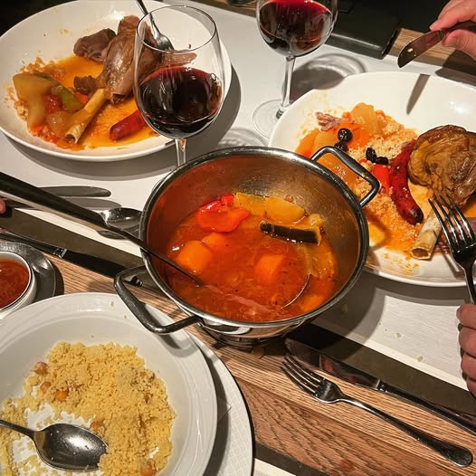 Couscous met groenten en rode wijn op tafel