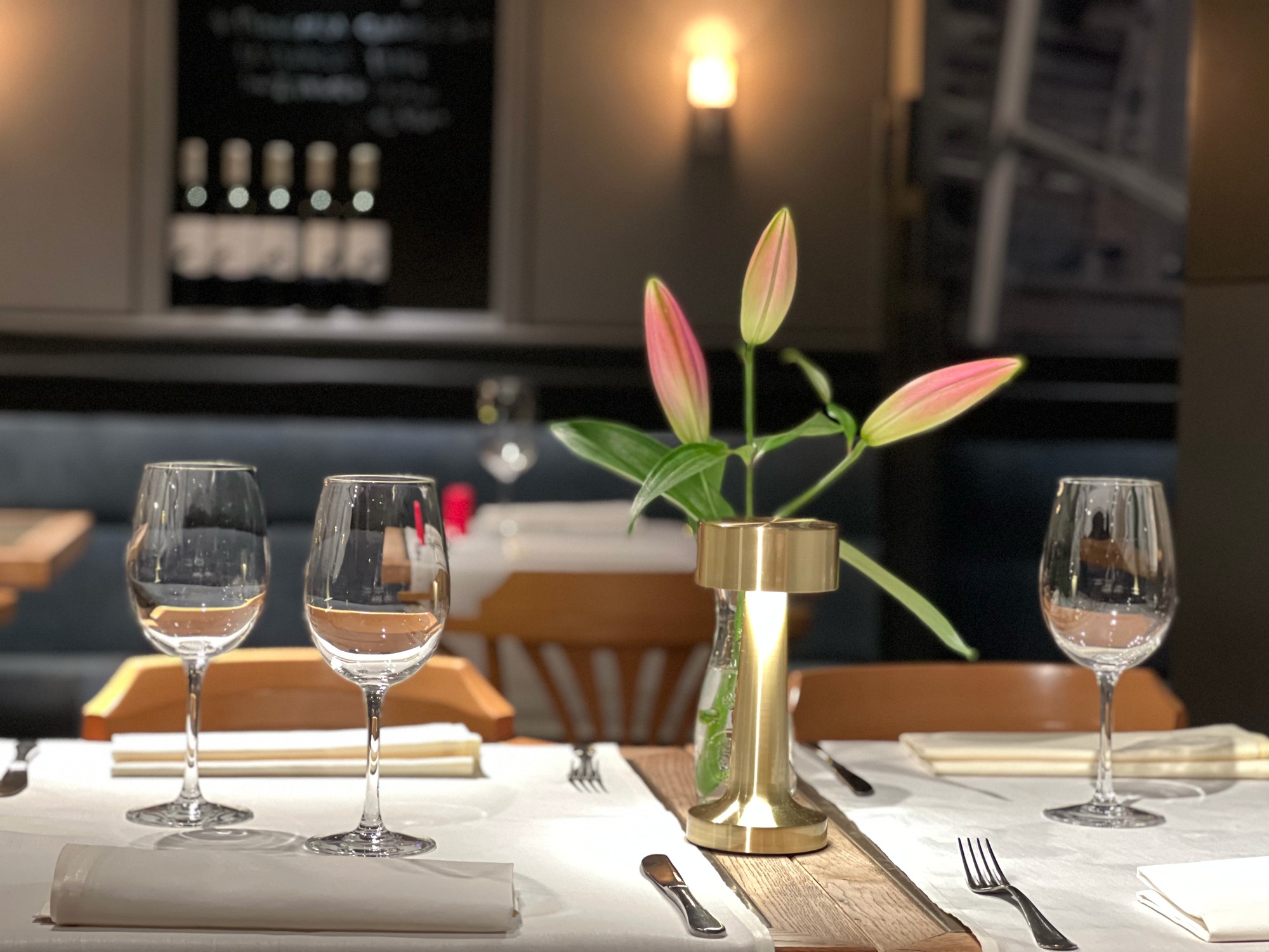 Gedekte tafel met lelie en brons lampje in de eetzaal