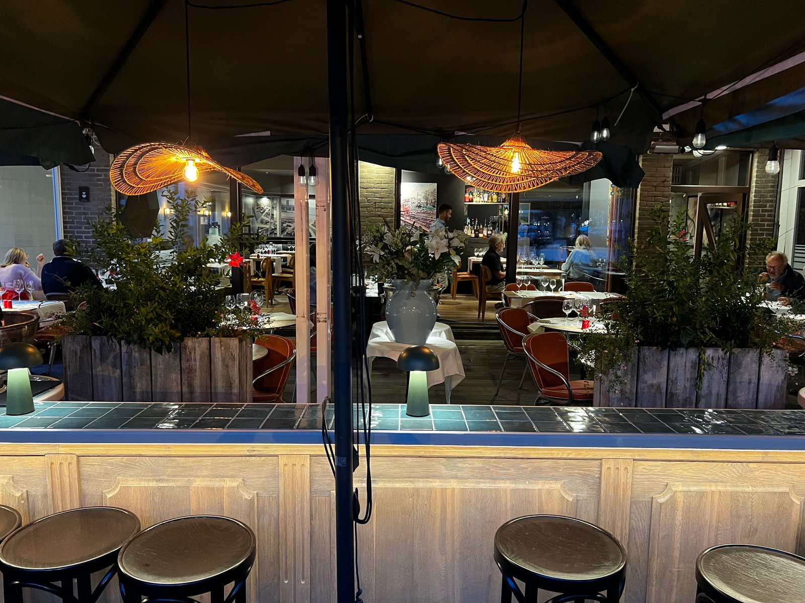 Gasten aan het terras van restaurant Petrus bij zonsondergang
