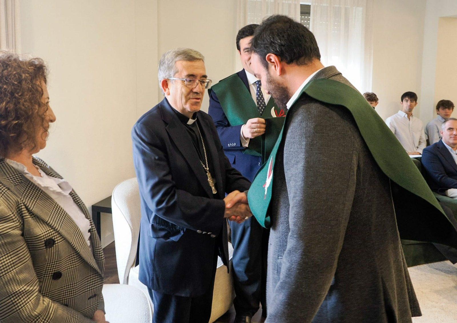 El arzobispo saluda a un colegial tras la imposición de becas
