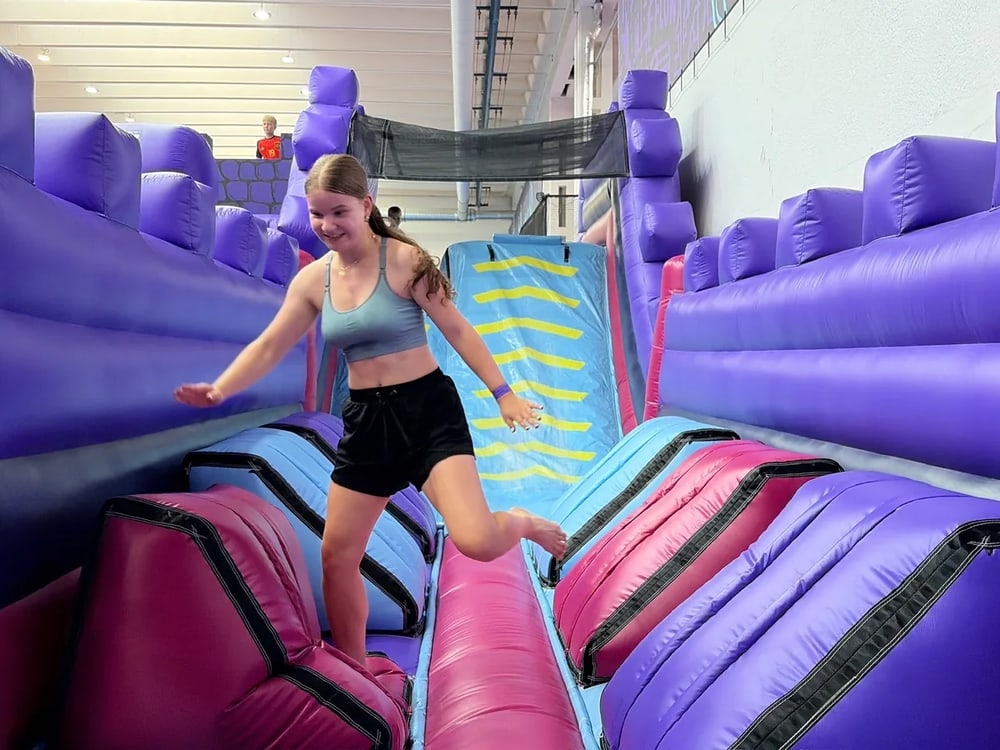 Dívka běhá po nafukovacím hradu UMPARK