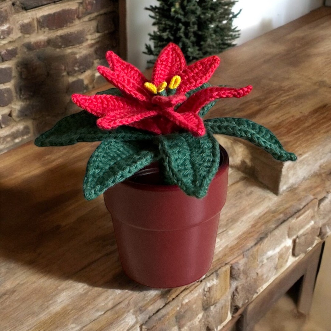 Handmade red crochet poinsettia plant in a burgundy red pot
