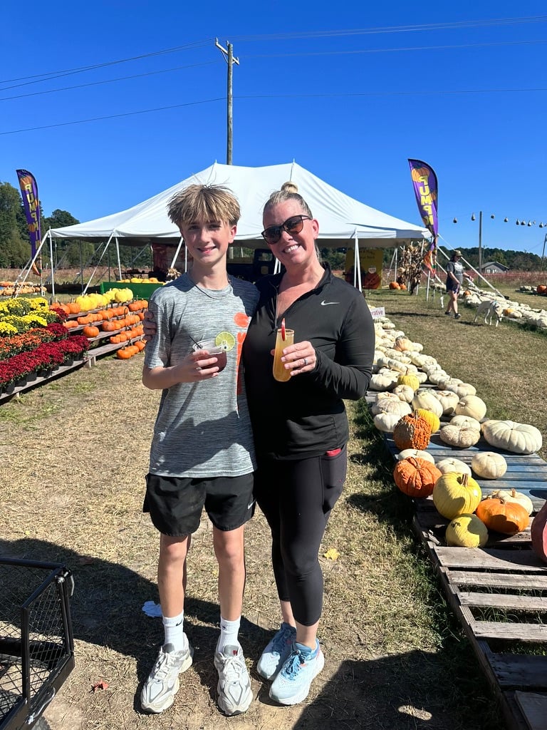 Guests smiling with hand-crafted drinks at a fall outdoor celebration