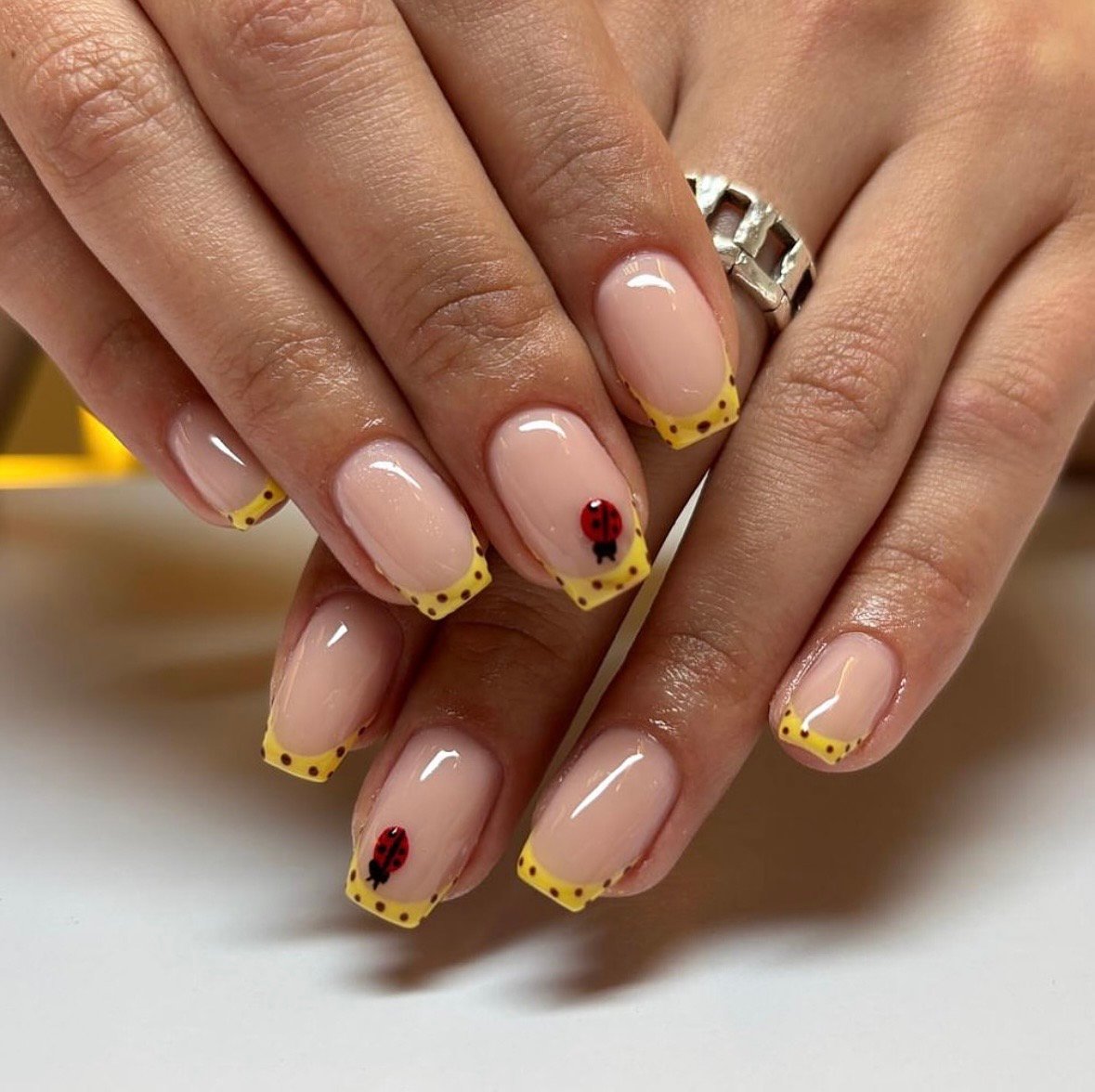 Yellow nails with ladybug art