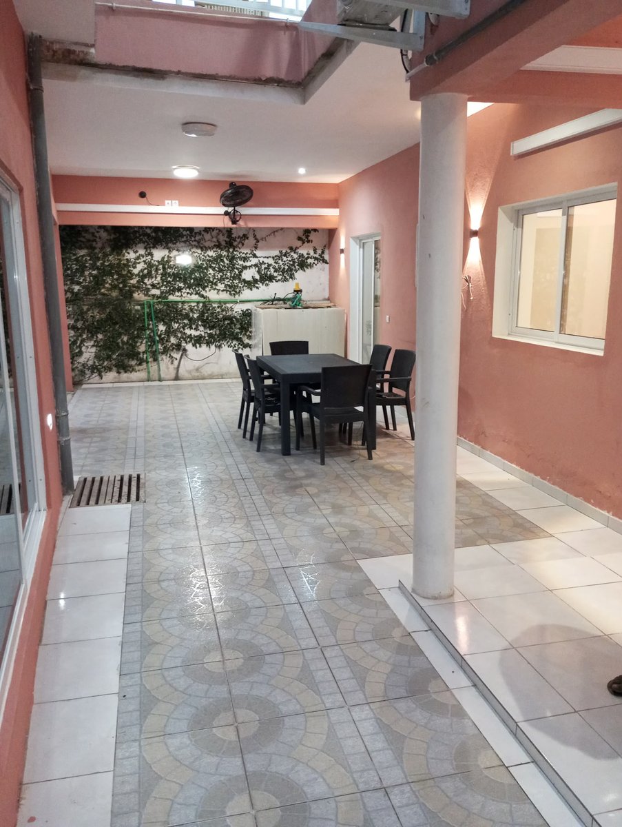 Covered terrace with dining table at Residencial Bigasso in São Tomé city