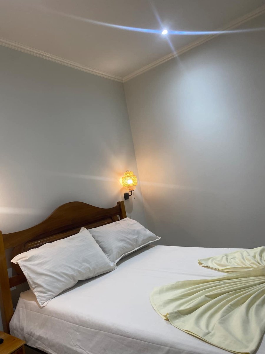 Guest bedroom with double bed and white tiled floor at Residencial Bigasso