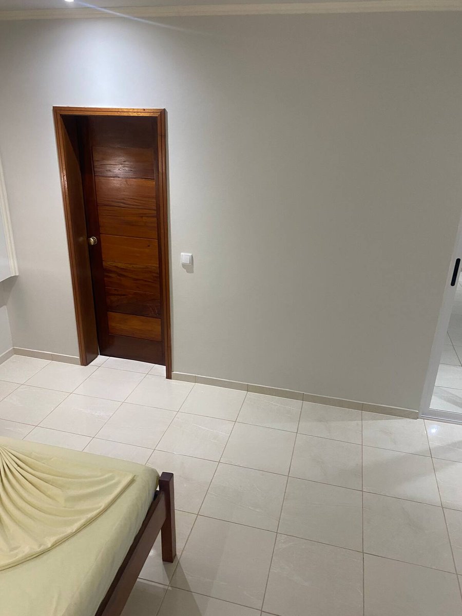 Bedroom corner with wooden door, wall mirror and soft lighting at Residencial Bigasso