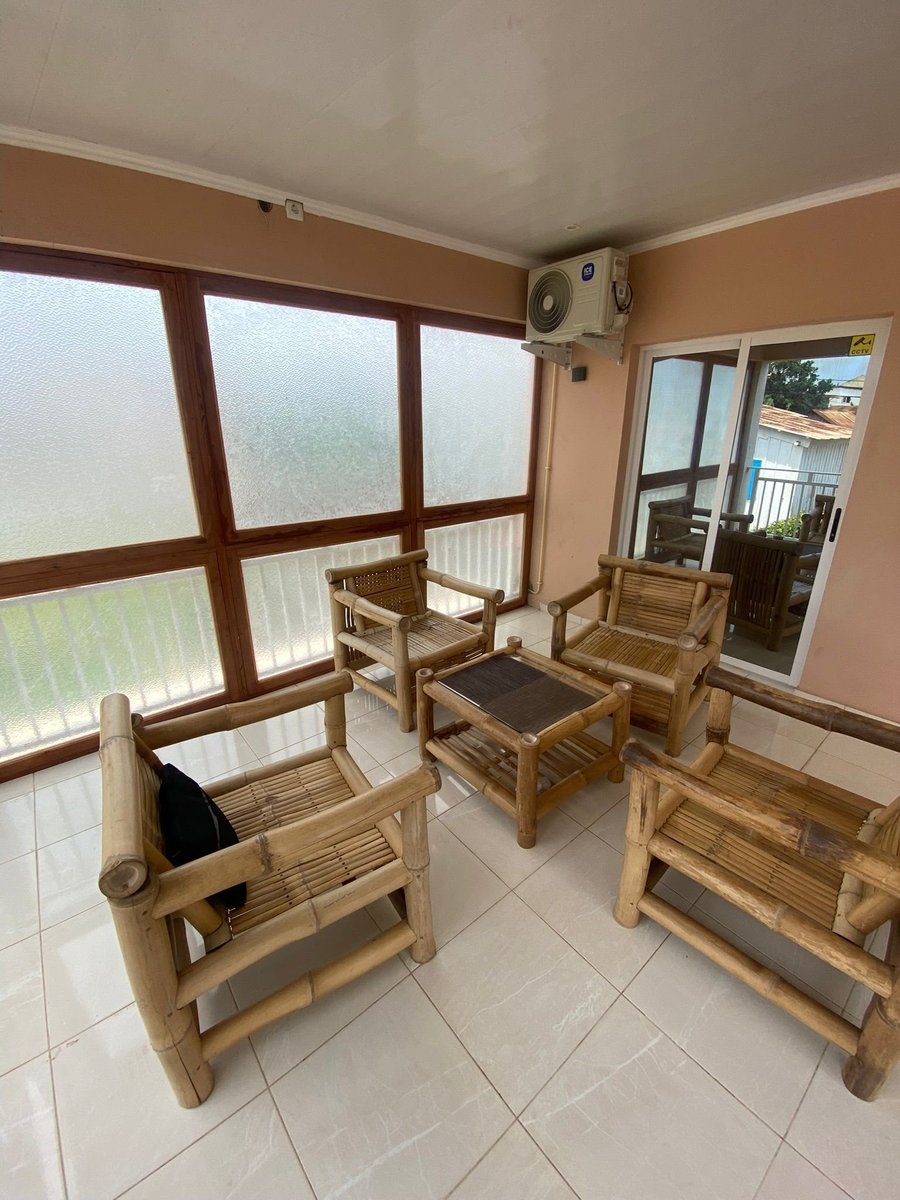 Bamboo armchairs in the glazed lounge at Residencial Bigasso in São Tomé city