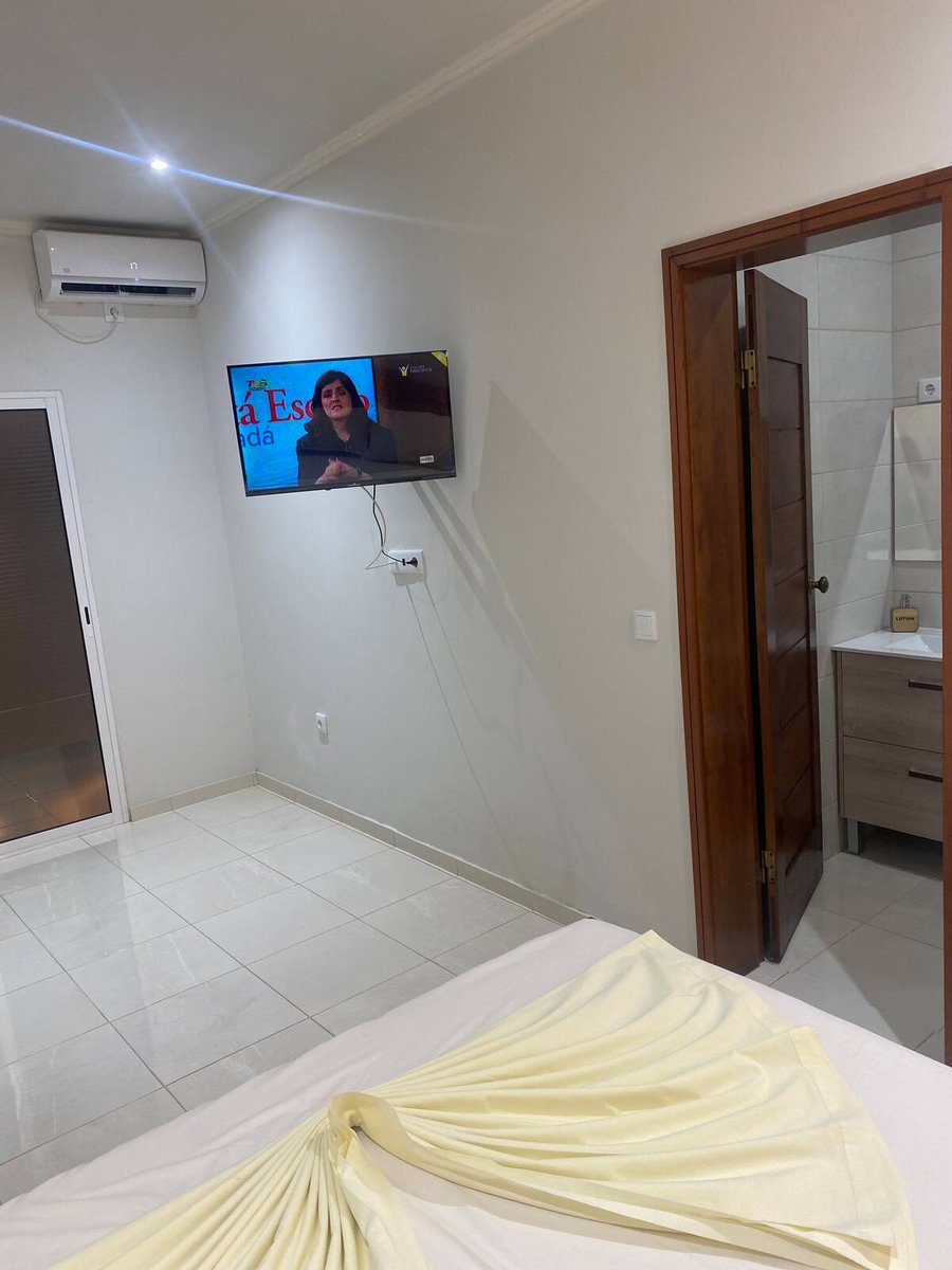 Master room with double bed, air conditioning, television and en-suite bathroom at Residencial Bigasso