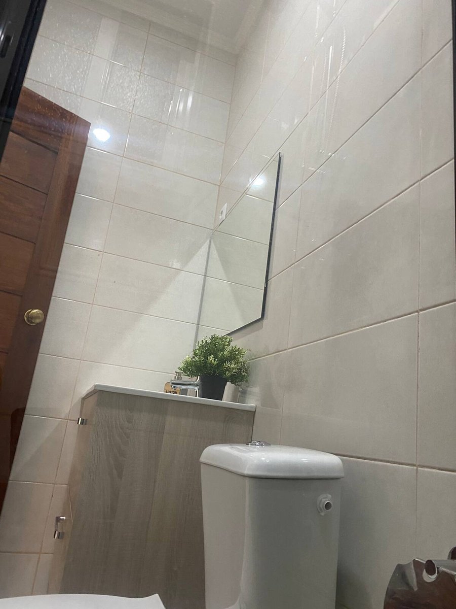 Private bathroom with white tiles, mirror and wooden vanity at Residencial Bigasso