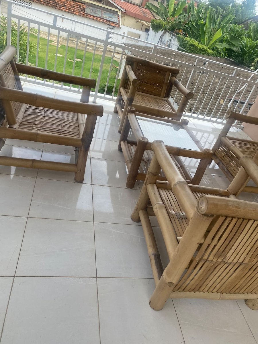 Balcony terrace with bamboo armchairs and a glass-top table overlooking the garden at Residencial Bigasso