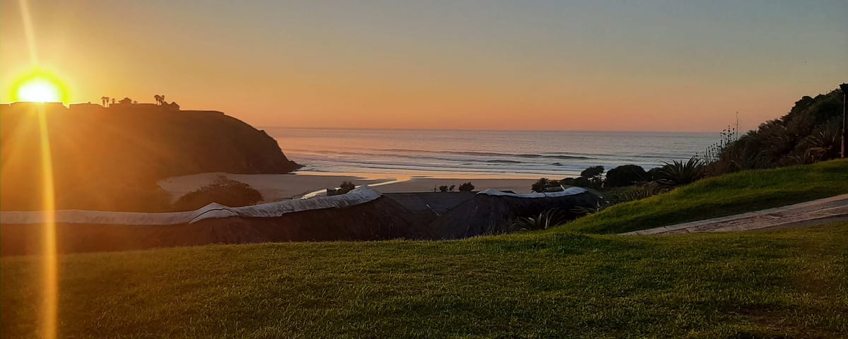 Sunrise over the beach and cottages at Hole in the Wall on South Africa's Wild Coast