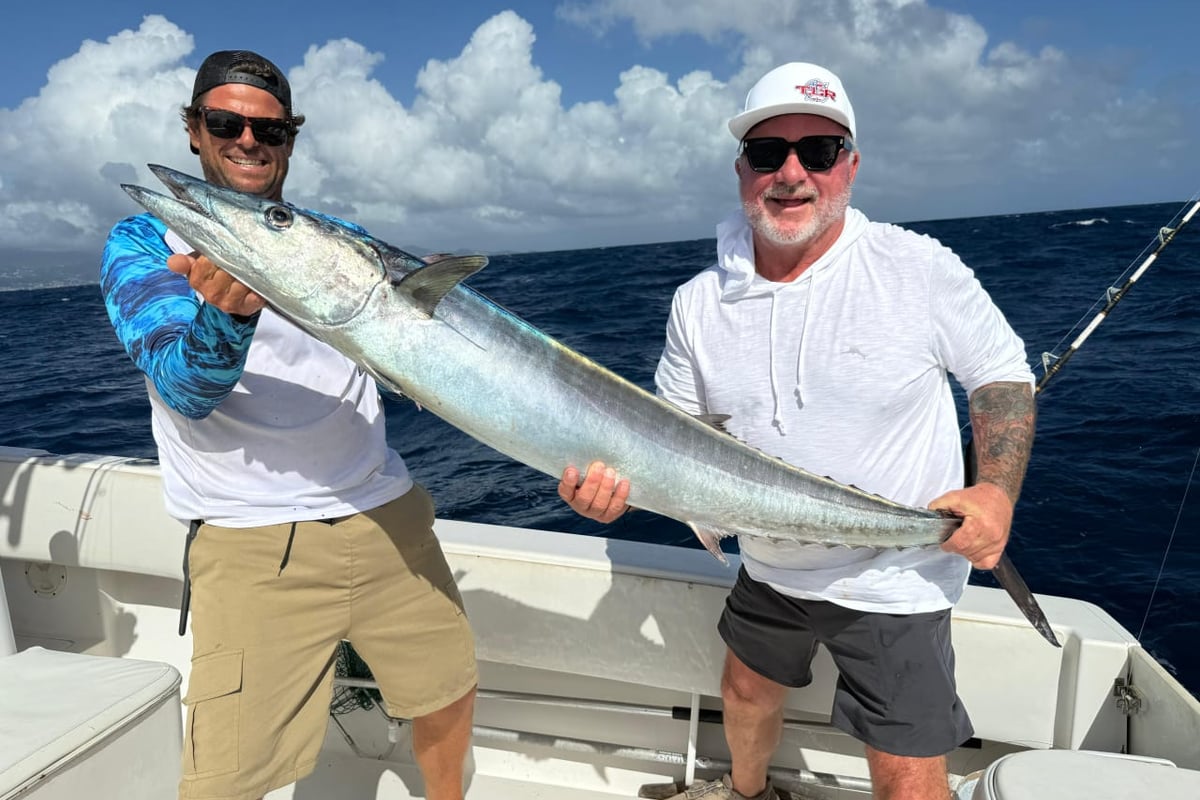 Anglers holding a large wahoo caught on a Grenadines Fishing charter offshore