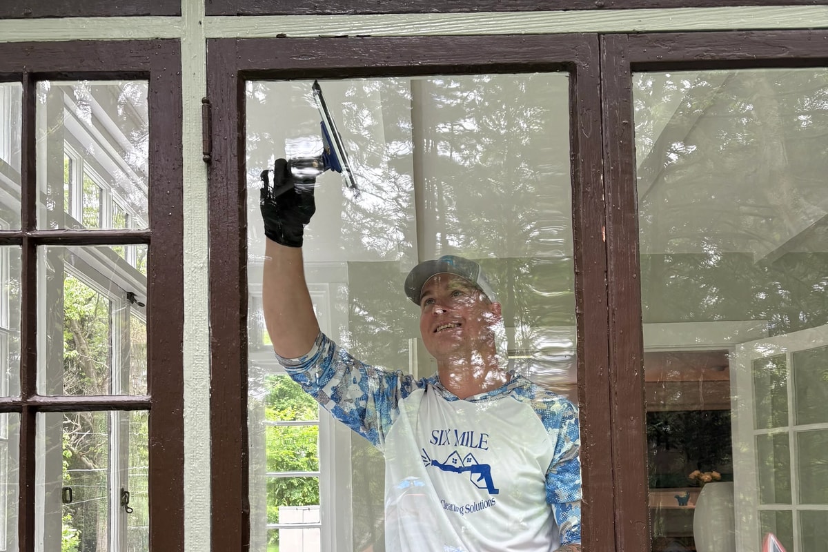 Oliver, founder of Six Mile Exterior Cleaning Solutions, cleaning windows