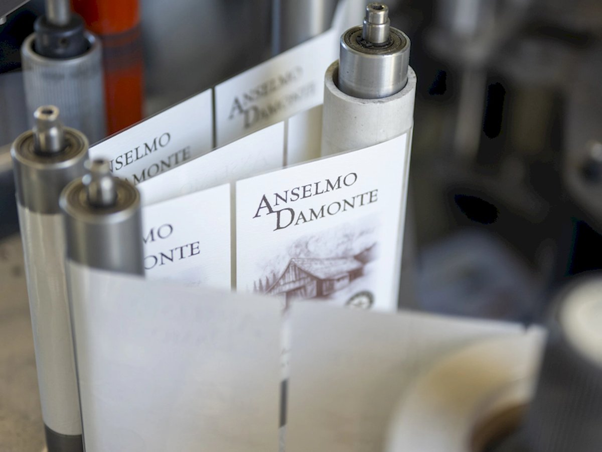 Anselmo Damonte wine labels rolling through the labeling machine