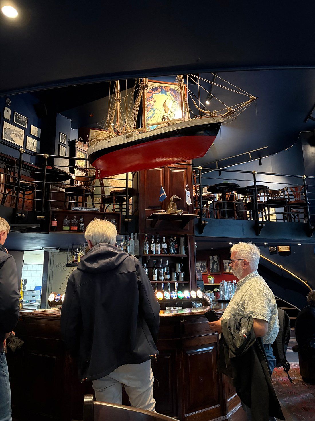 Group toasting with aquavit in a historic Norwegian tavern with maritime decor