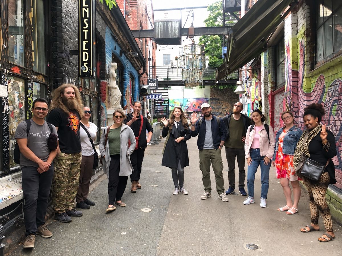Tour group waving in a colourful street-art alley in Grünerløkka