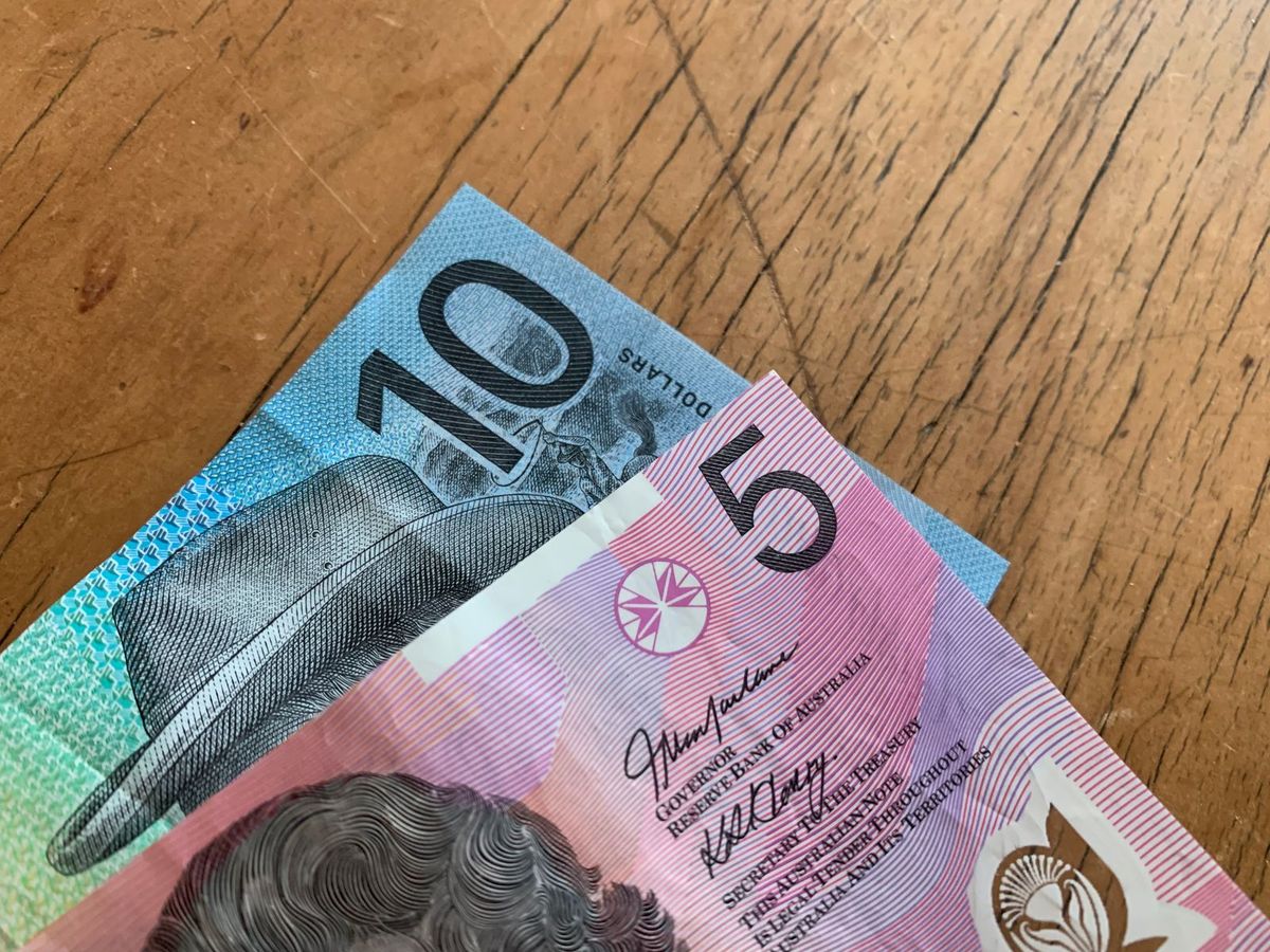Australian five and ten dollar notes on a wooden surface