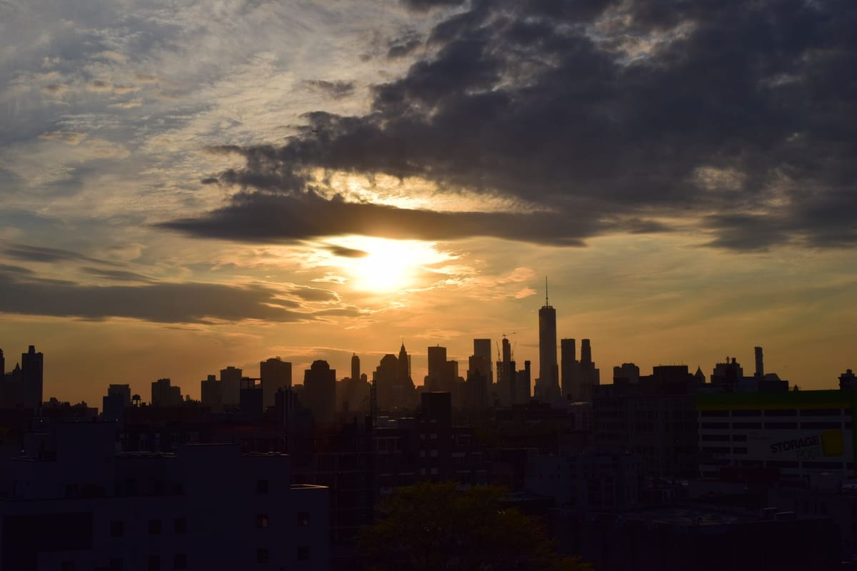 The New York City skyline silhouetted against a sunset sky