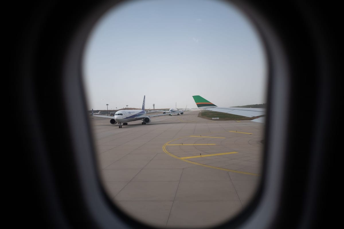 An aeroplane on the tarmac seen through an airport window