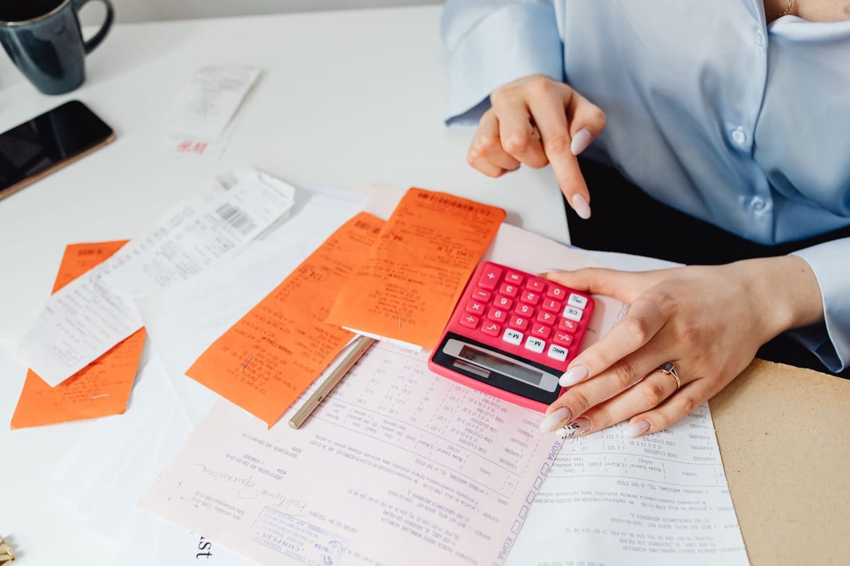 Receipts spread out beside a calculator on a desk