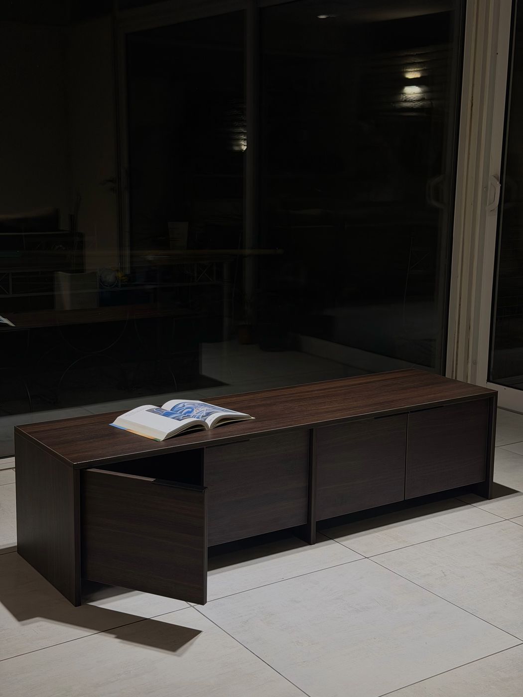 Mueble en stock — foto real de noche, puerta entreabierta con libro