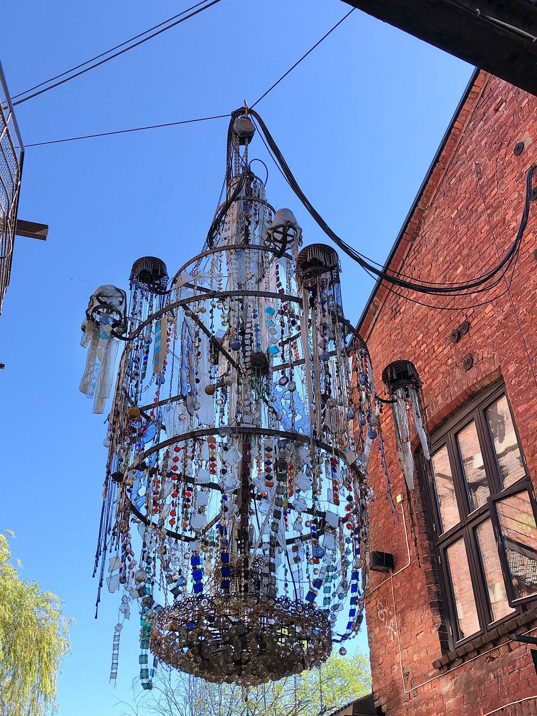 Courtyard in Grünerløkka with a large beaded chandelier installation and mural walls