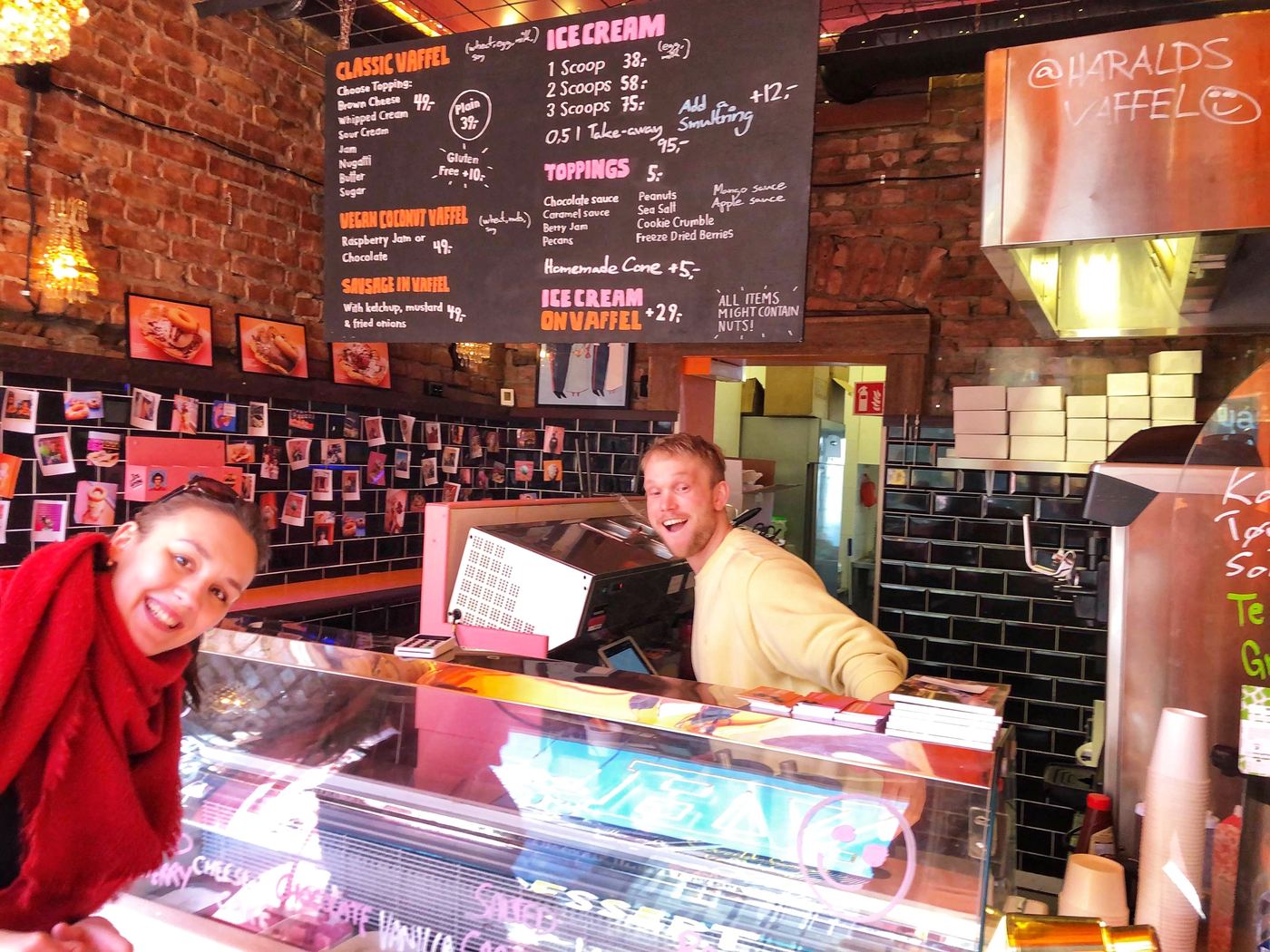 OsloWay's founder at the counter of Haralds Vaffel, a small Oslo waffle bar, with the menu board above