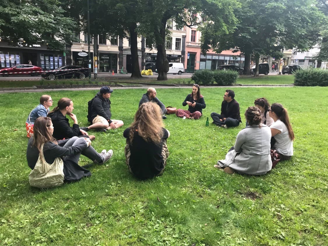 A small OsloWay group gathered around their guide in a Grünerløkka park