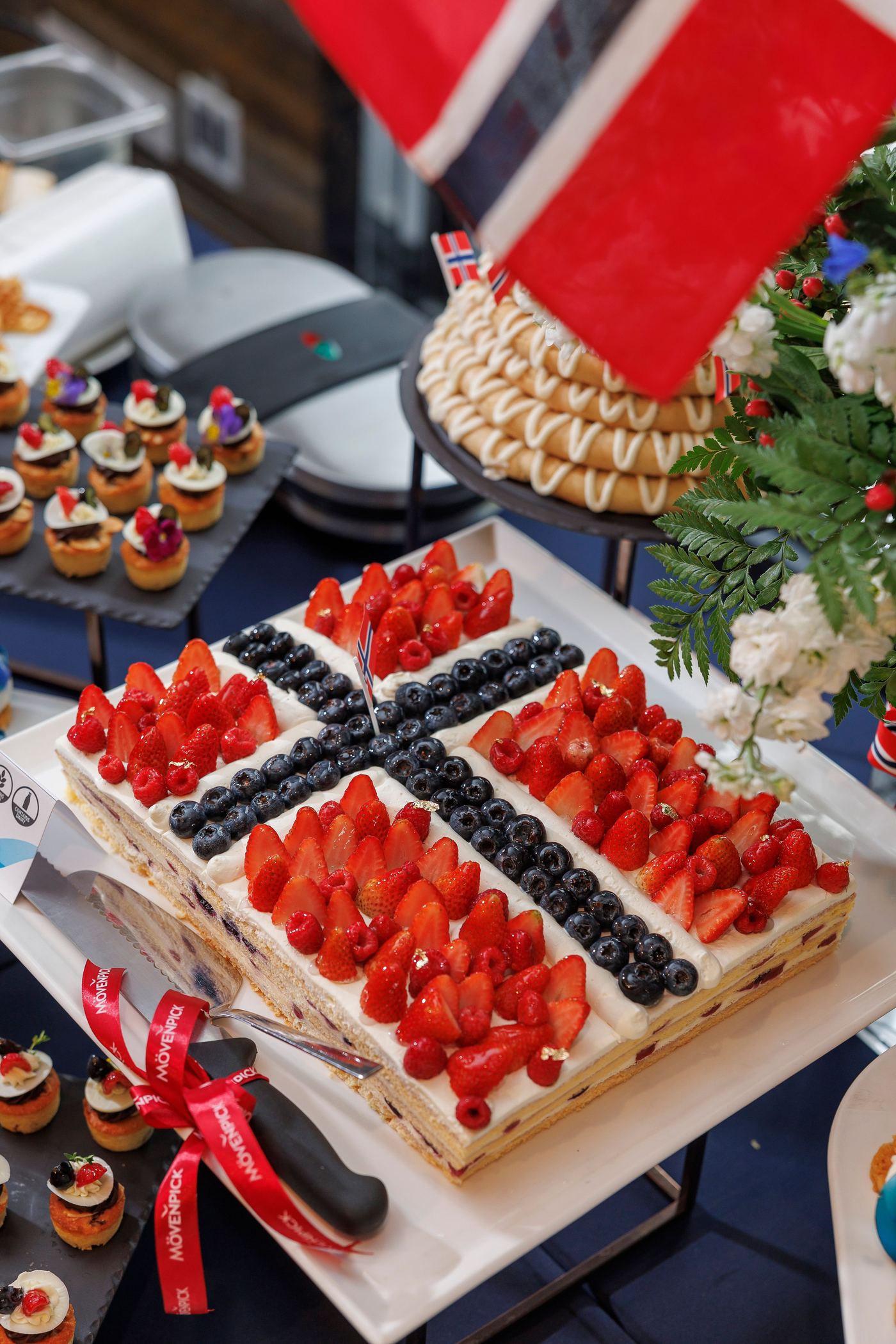 Layered Norwegian cream cake decorated with fresh strawberries and blueberries
