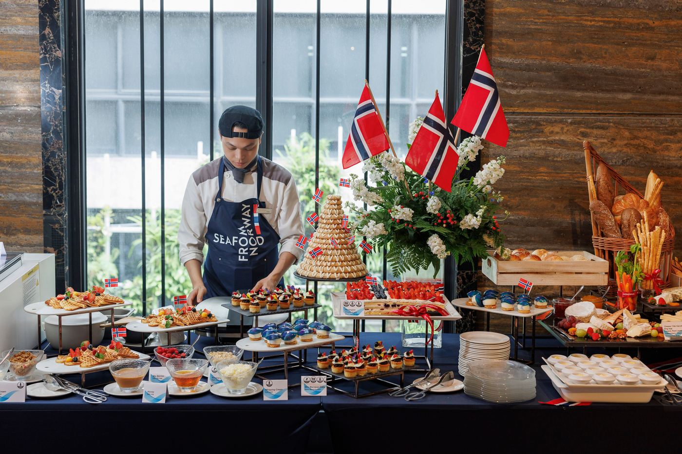 Modern Norwegian buffet table with waffles, berries, kransekake cake and Norwegian flags