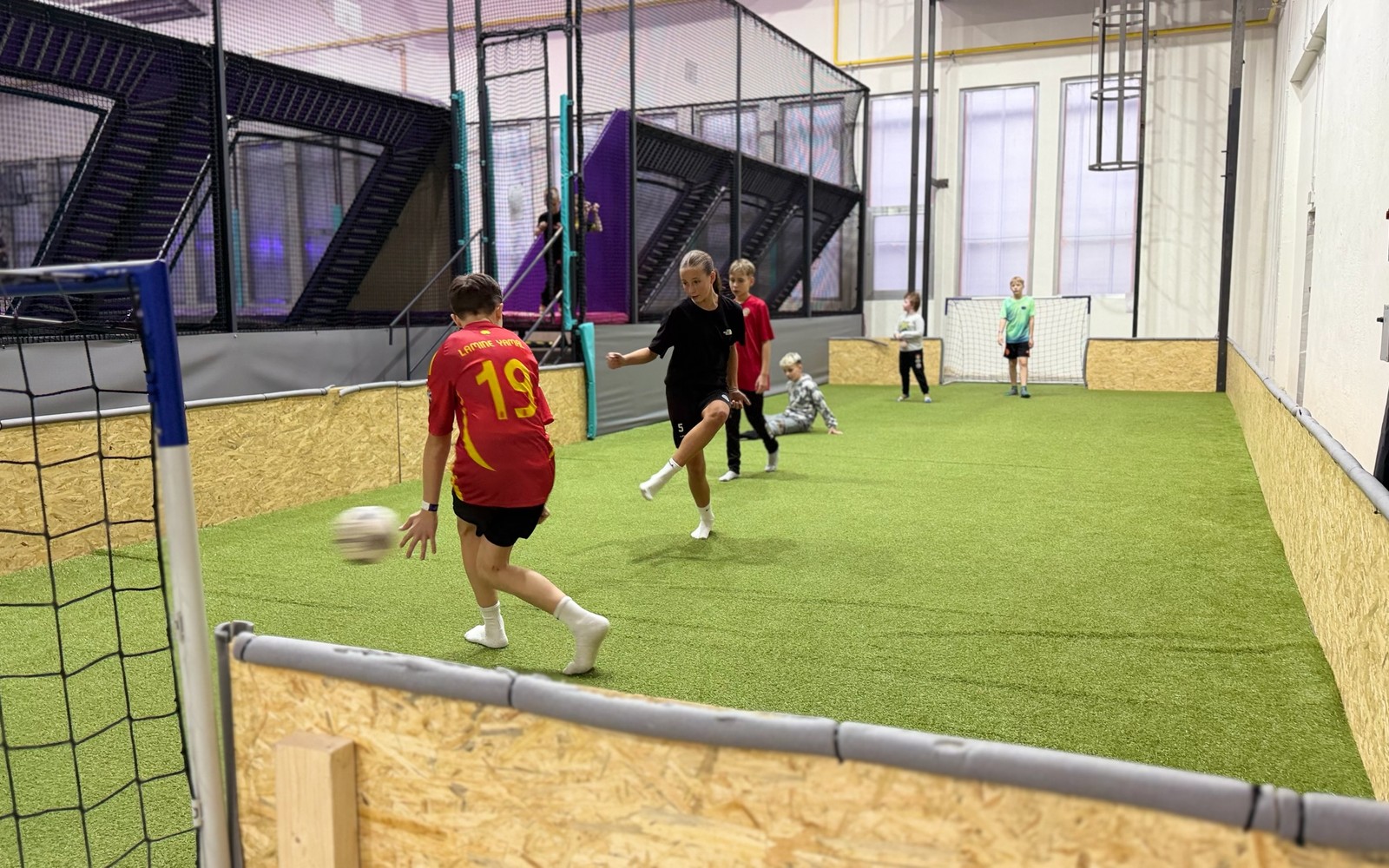 Fotbal v hale UMPARK s trampolínami v pozadí