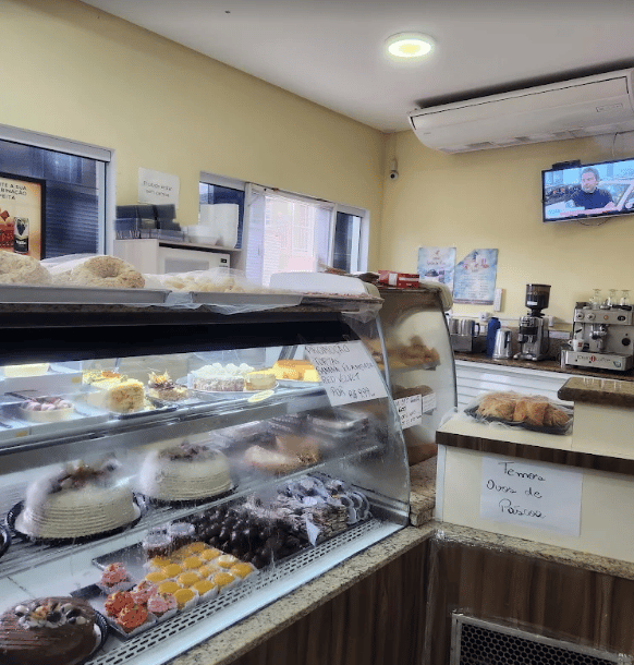 Taças de sobremesa e bolos de pote com a caixa da Padaria Assis ao fundo