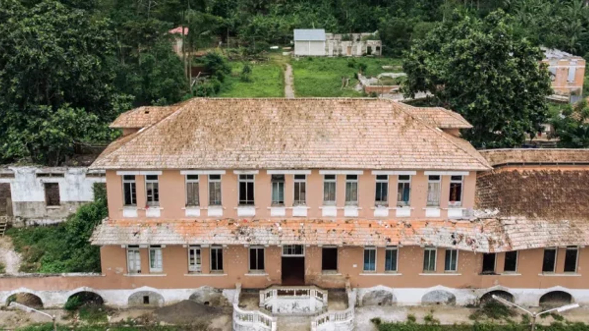 A longa alameda da Roça Agostinho Neto, São Tomé, ladeada de habitações operárias coloniais