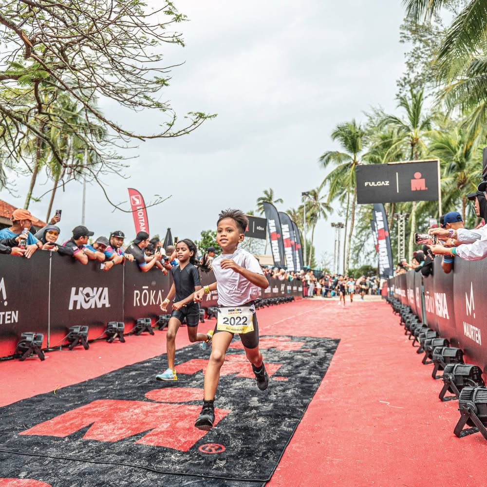 Children running along a road past spectators during an IRONKIDS event (1 of 3)