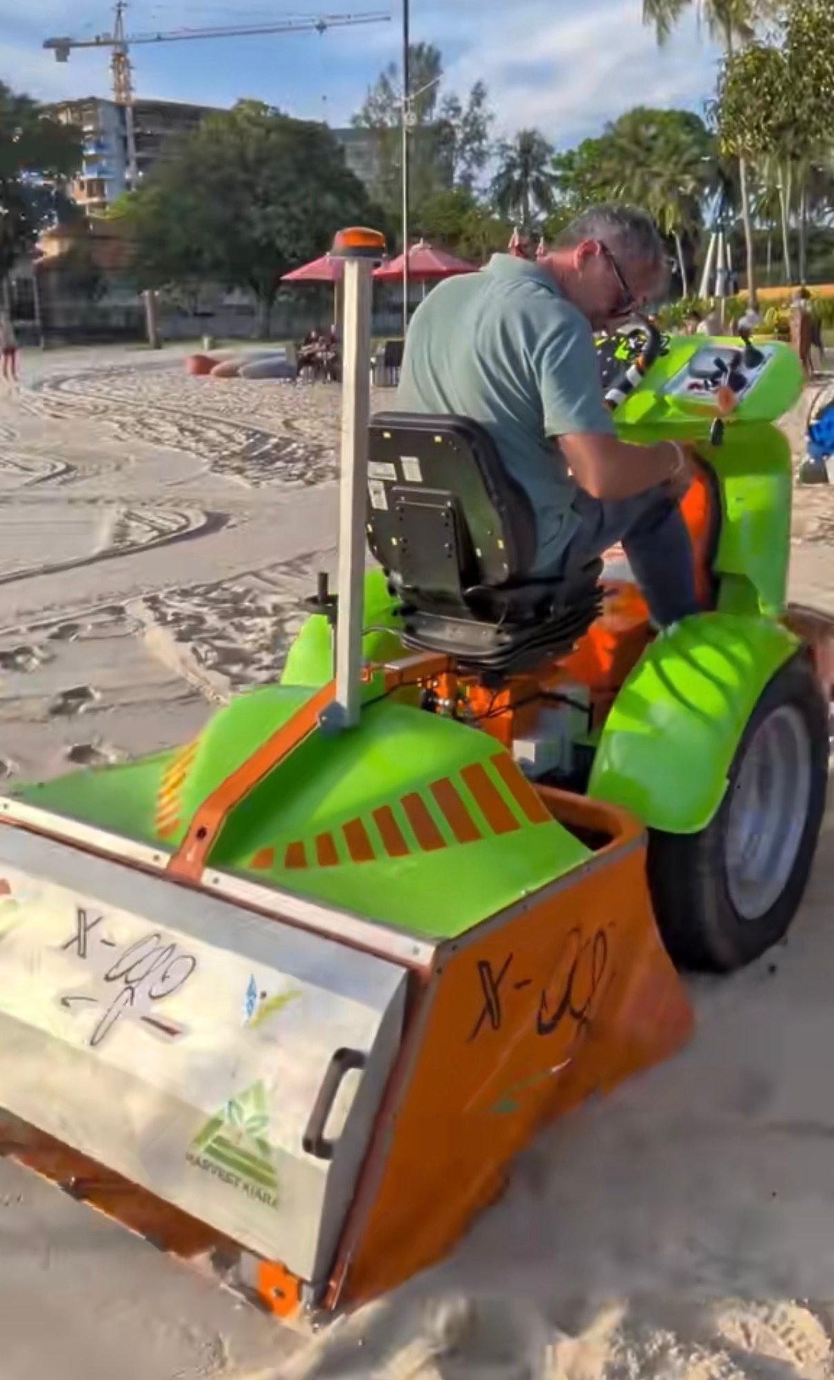 A beach cleaning machine in use on the sand at Pantai Tengah