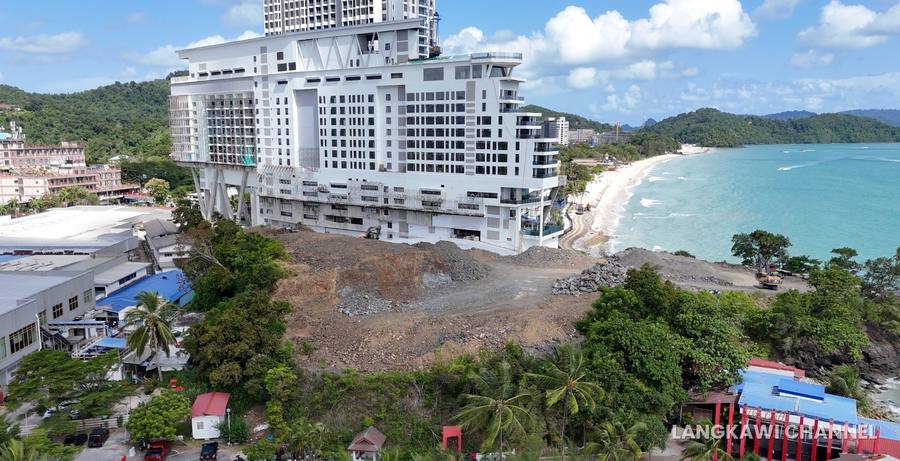 Wide aerial view of the levelled Dropstone hill site at Pantai Cenang, cleared of vegetation and ready for construction